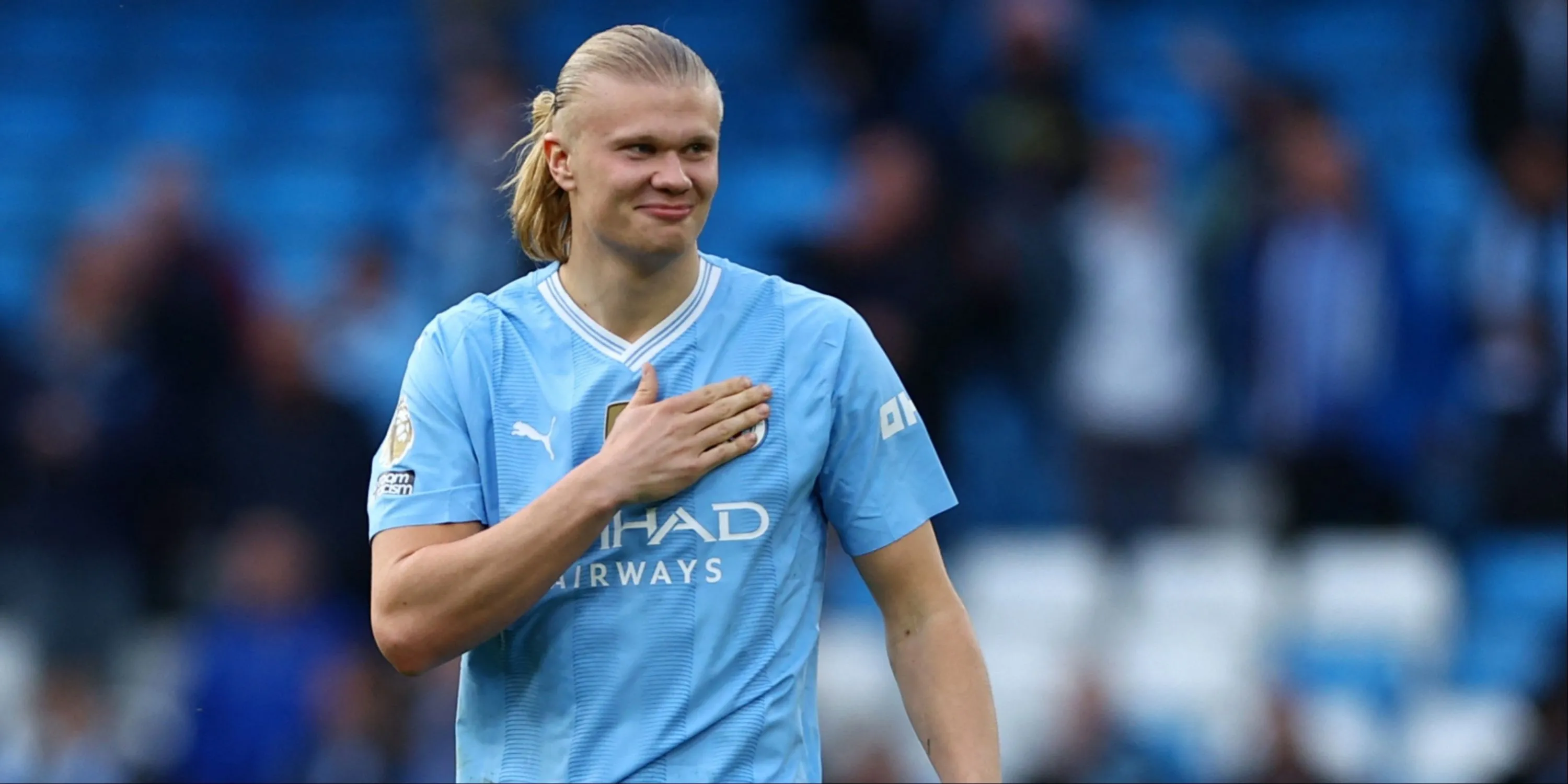 Erling Haaland vỗ vào logo Manchester City, thể hiện niềm tự hào với màu áo CLB